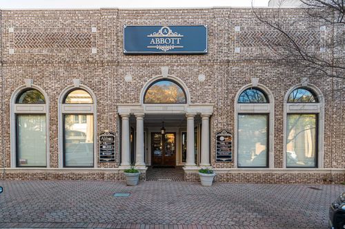 The Abbott Building’s brick Main Street facade, with the navy Abbott Atrium sign above its arched windows.
