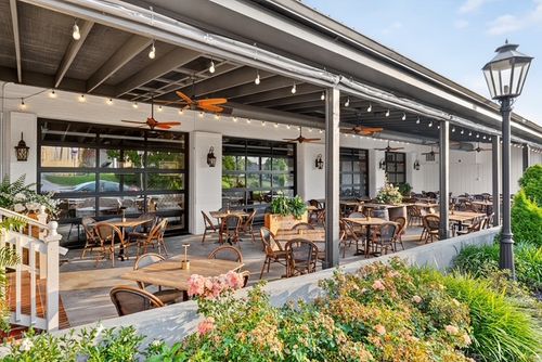 Outdoor patio seating at Brûlée, lit with string lights.
