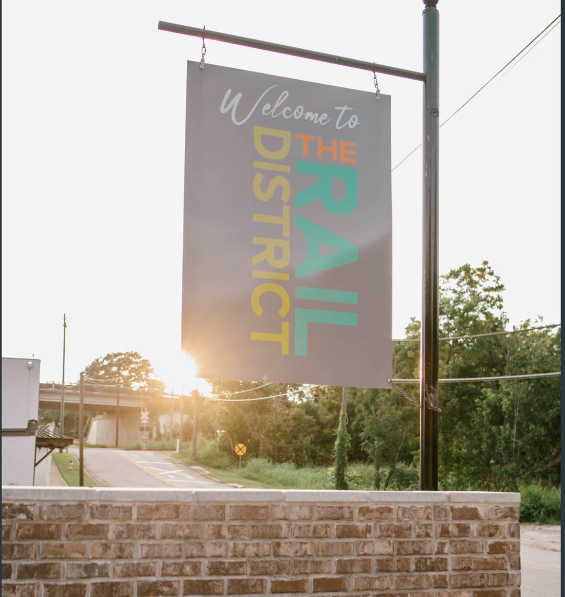 "Welcome to the Rail District" banner sign, daytime.