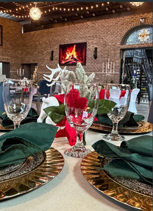 A finely set dining room table beside a fireplace.