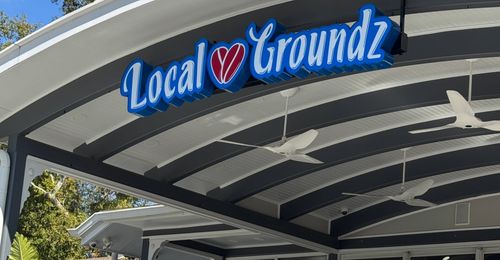 Local Groundz storefront sign beneath a columned porch.